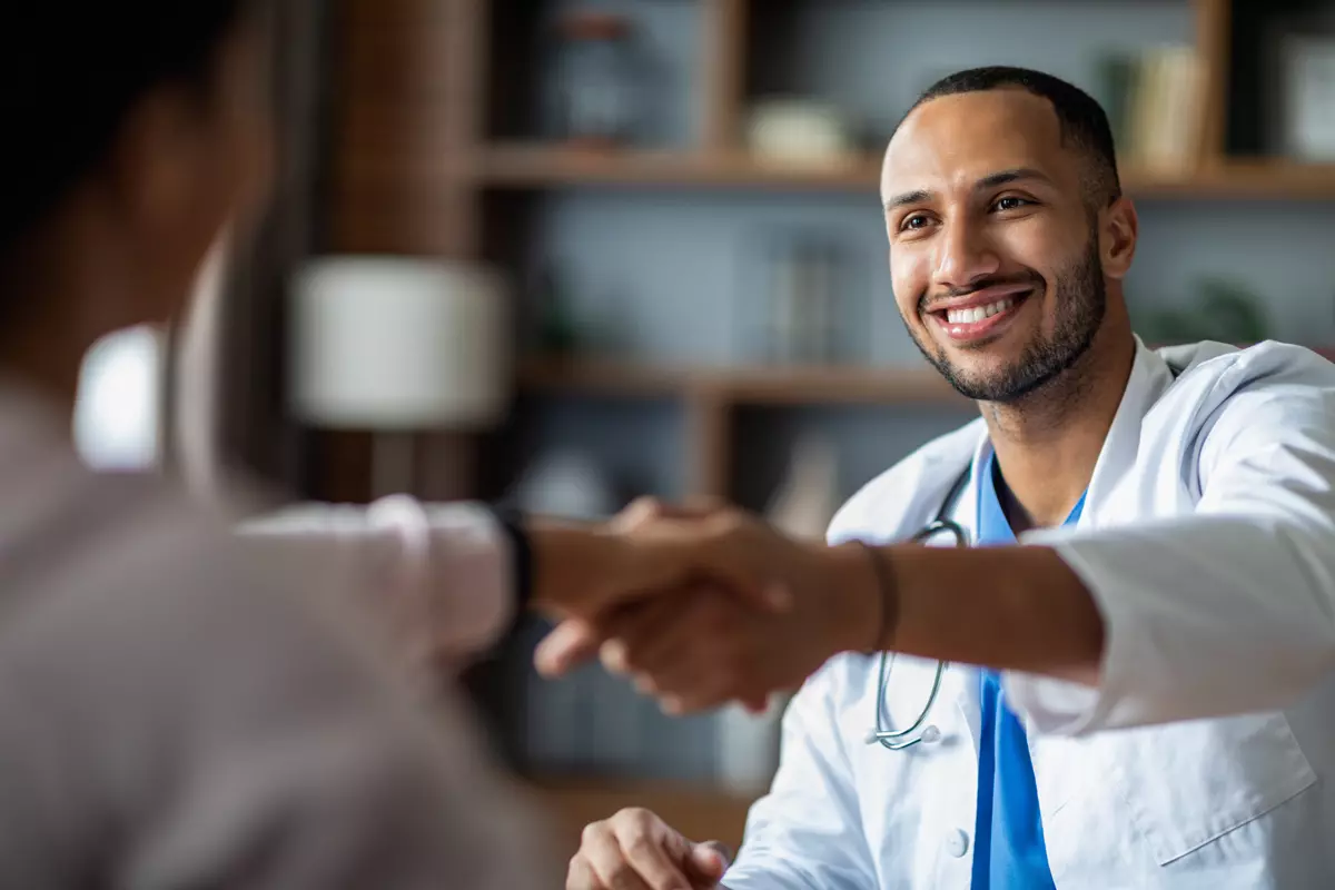 two physicians shaking hands and smiling